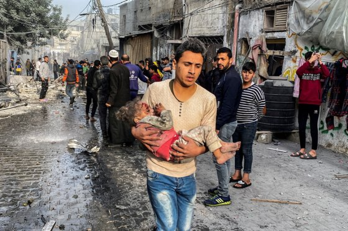 휴전이 끝나 1일 이스라엘의 공격을 받은 가자지구 남부의 라파. 한 팔레스타인 사람이 부상당한 어린 아이를 들고 다급하게 이동하고 있다. 로이터=연합뉴스