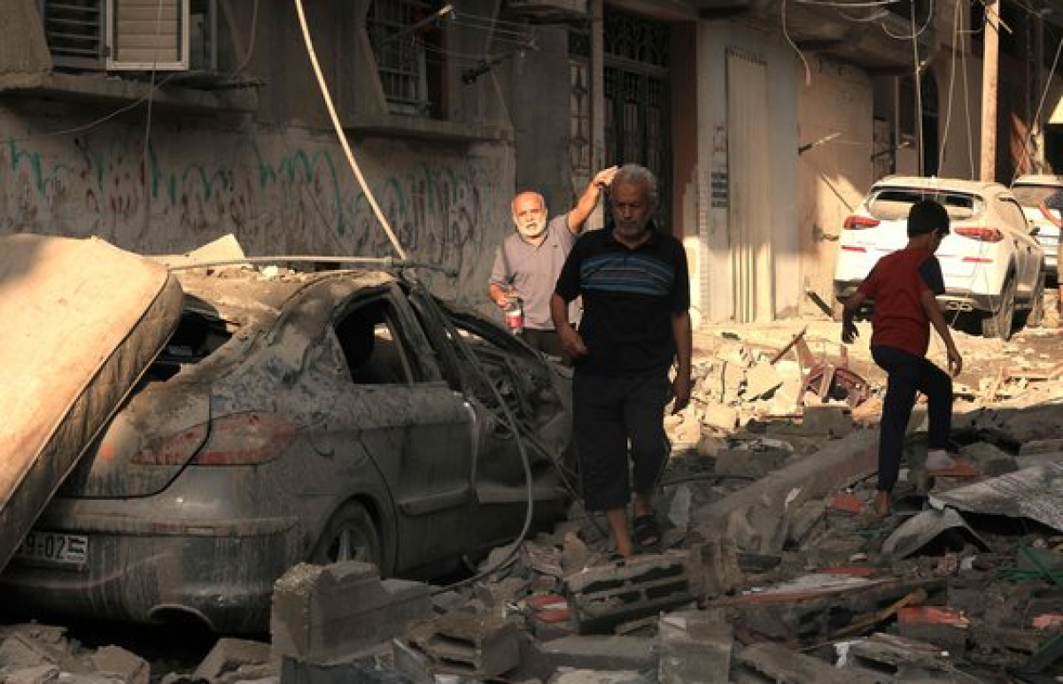 이스라엘의 포격을 받아 무너진 가자지구의 건물 잔해 위를 걷는 사람들. AFP=연합뉴스