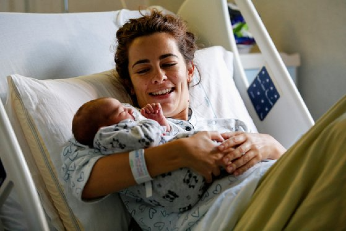 지난 14일 이탈리아 로마의 한 병원에서 한 산모가 방금 태어난 신생아를 안고 웃고 있다. 로이터=연합뉴스