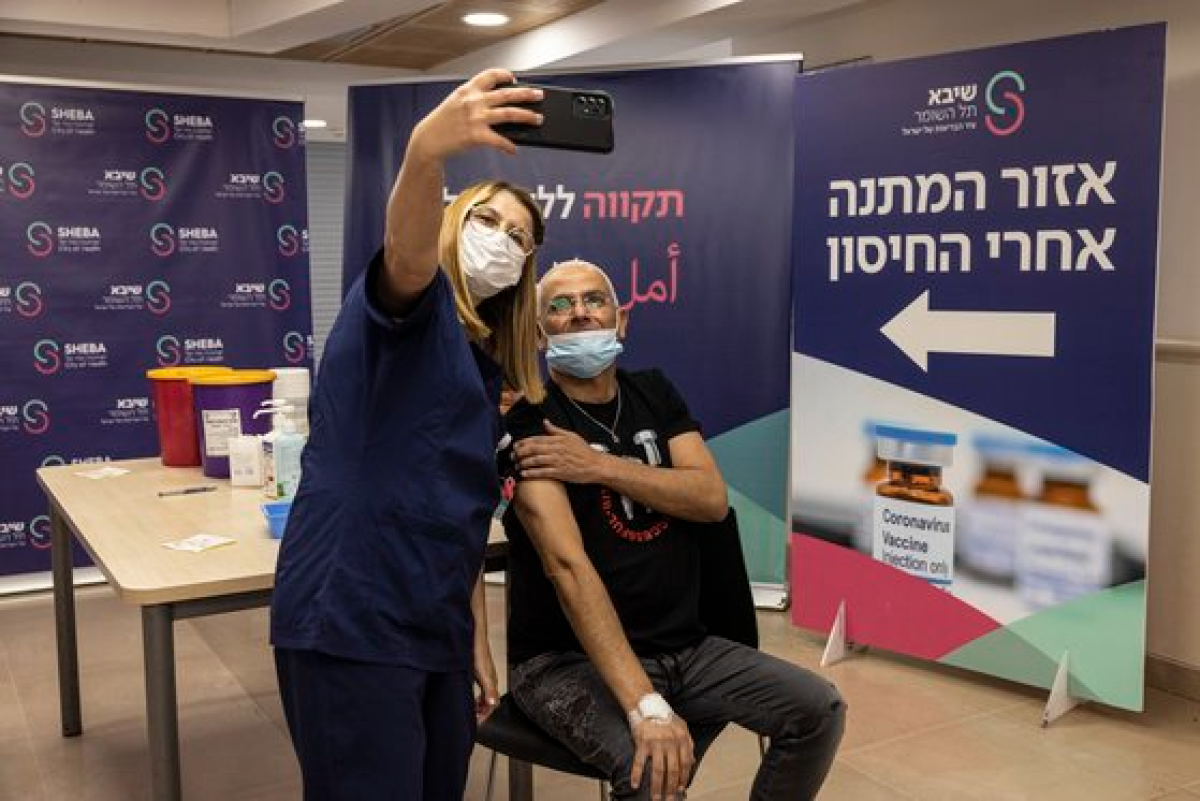 31일(현지시간) 이스라엘에서 4차 접종을 한 시민과 의료진이 기념 촬영을 하고 있다. [AP=연합뉴스]