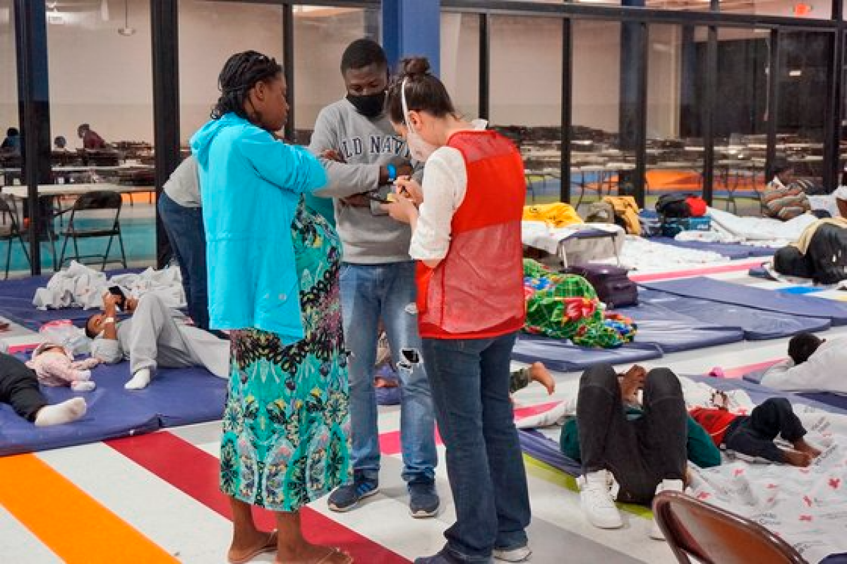 작년 12월 미국 텍사스 매켈런의 한 이민자 휴식 센터에서 한 자원 봉사자가 임신부 이민자를 돕고 있다. AP=연합뉴스