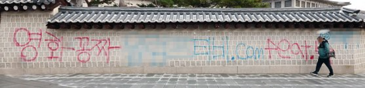 16일 오전 서울 종로구 국립고궁박물관 방향 경복궁 서쪽 담벼락에 붉은색과 푸른색 스프레이로 '영화공짜'라고 쓴 낙서가 적혀있다. 연합뉴스