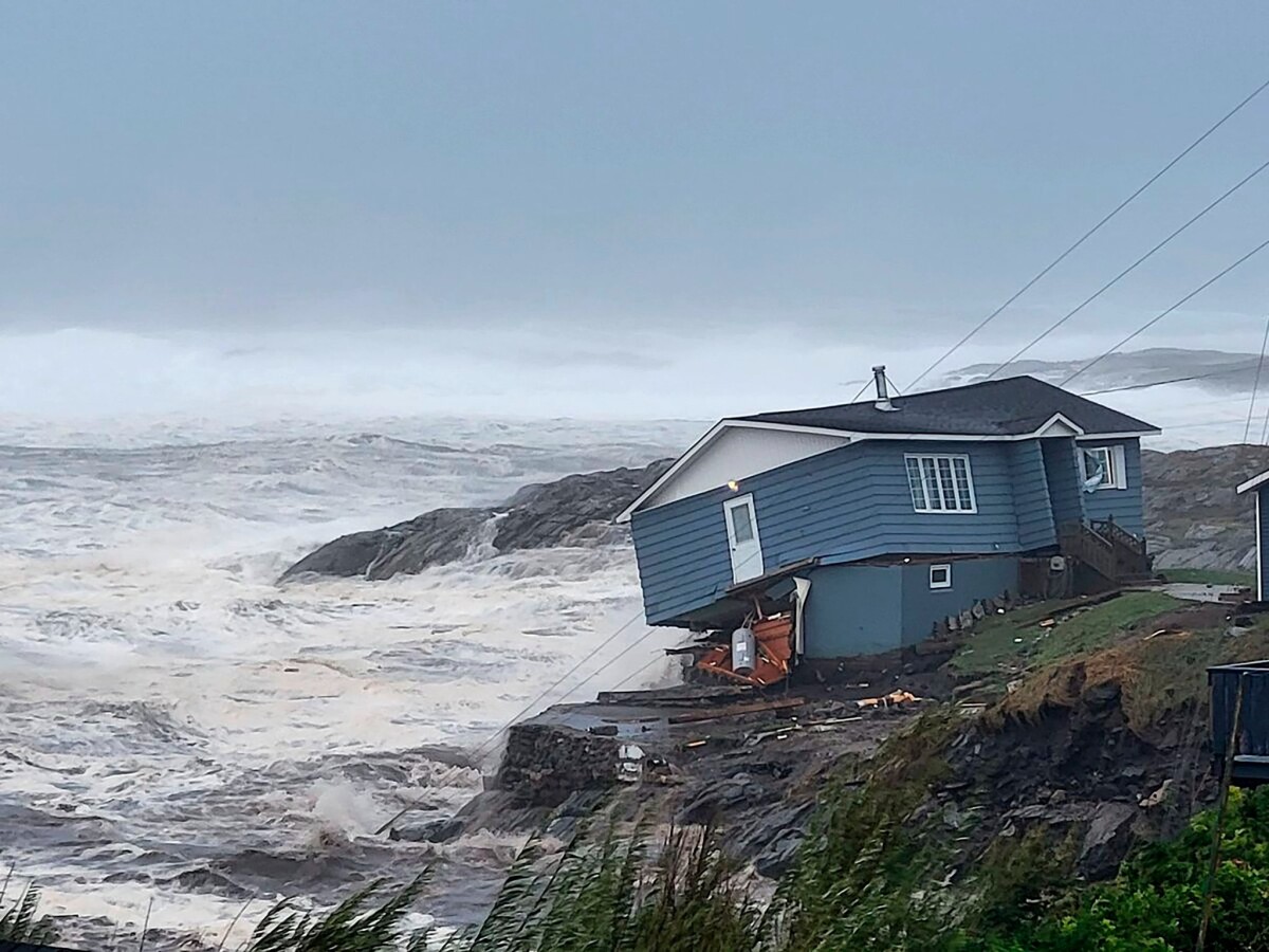 25일(현지시간) 캐나다 뉴펀들랜드와 해안에 불어닥친 강풍과 해일로 주택이 넘어질 듯 쓰러져 있다. AP=연합뉴스