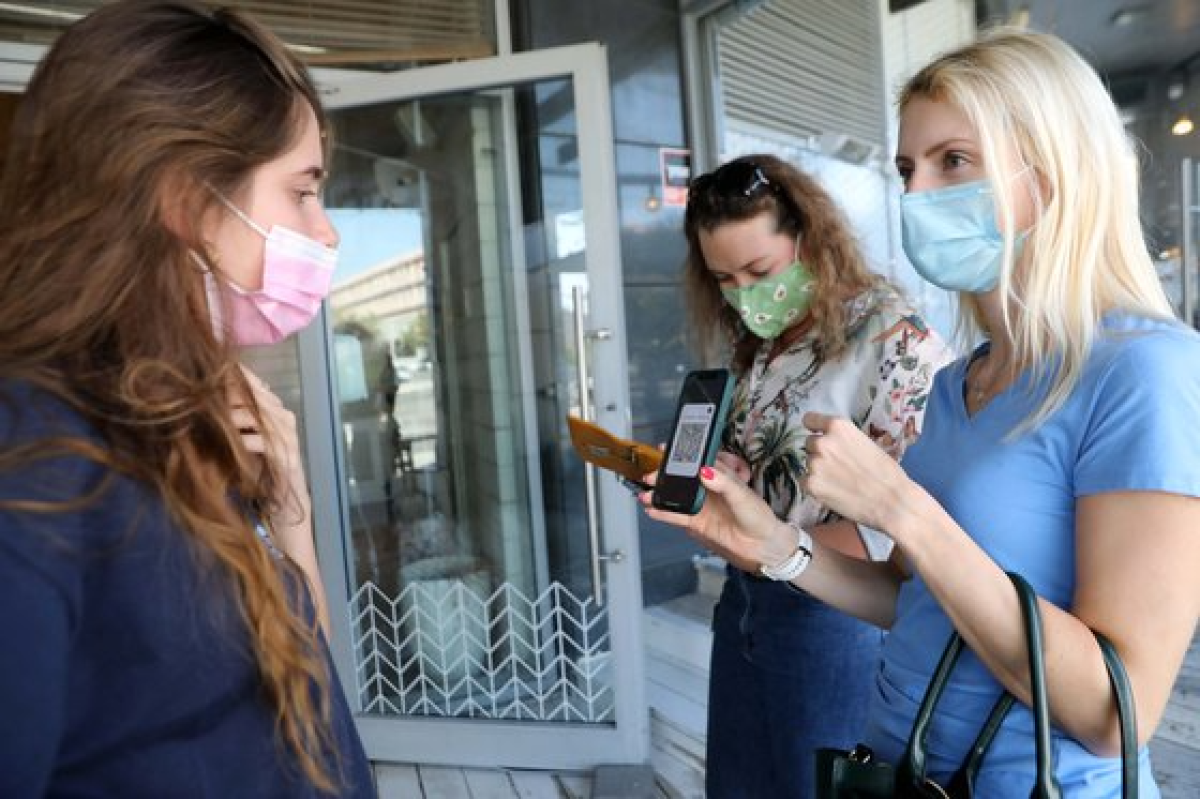 이스라엘의 한 식당 입구에서 방문객이 백신 패스를 보여주고 있다.[신화통신=연합뉴스]