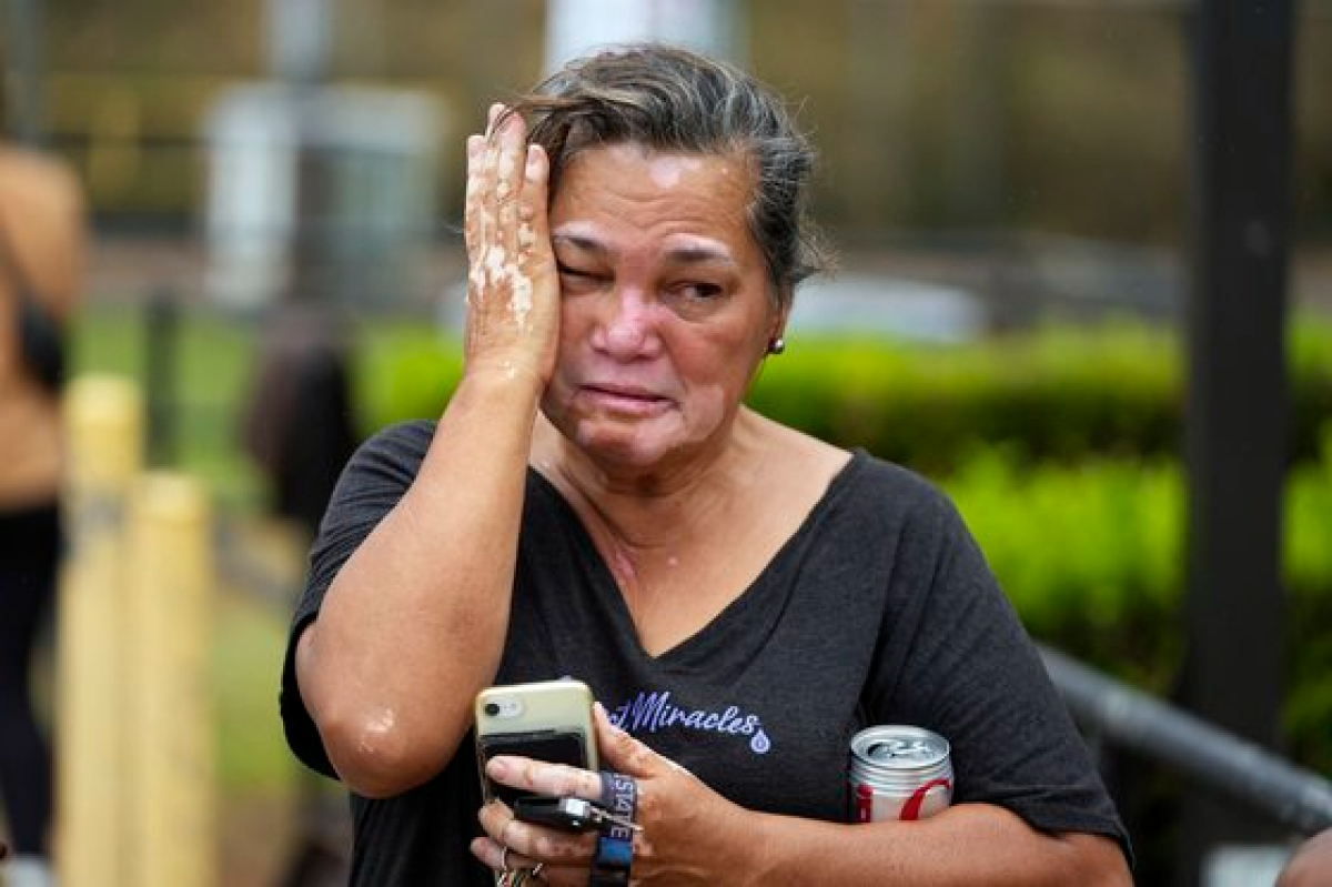 미국 하와이에서 13일째 산불이 이어지는 가운데, 전쟁 기념 체육관의 대피 센터 앞에서 한 여성이 가족들을 찾으며 눈물을 흘리고 있다. AP=연합뉴스